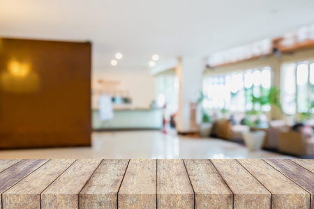 wood table with hotel reception lobby blur backgroundの写真素材