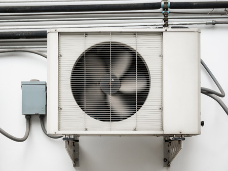 Air conditioner compressor unit installed outdoor in the old buildingの写真素材