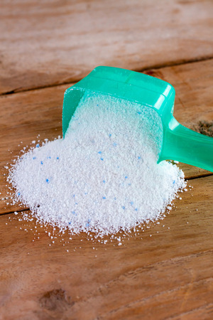 Detergent powder, detergent washing powder in the measuring spoon on wood backgroundの写真素材