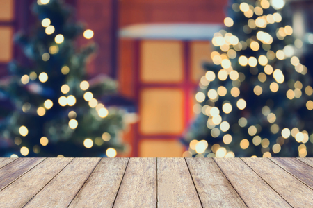 Christmas holiday background with empty wooden table top over festive bokeh light decorate on Christmas tree. For create montage product displayの写真素材