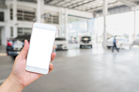 Woman using mobile smartphone with blur cars parking backgroundの写真素材