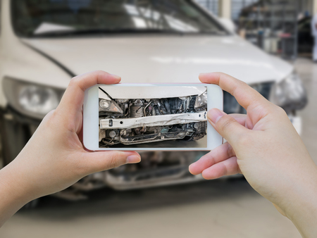 female hold mobile smartphone photographing car accident for insuranceの写真素材