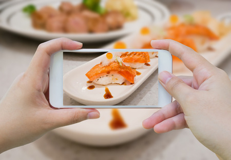 Taking photo of Grilled salmon sushi on white plateの写真素材