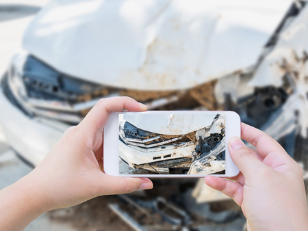 Female using mobile smart phone taking photo of the car crash accident damage for insurance