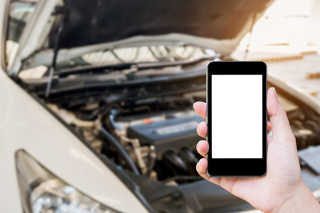 woman using mobile smart phone with broken down car background, emergency service conceptの写真素材