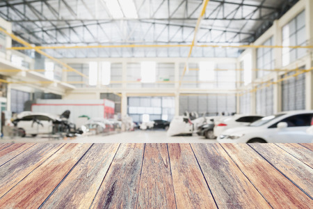 Wood table top with Car repair service centre interior blurred background. For create montage auto product display.の写真素材