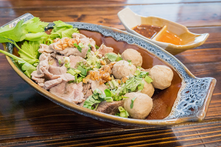 Thai food, meat balls and beef with spicy sauce on wood tableの写真素材