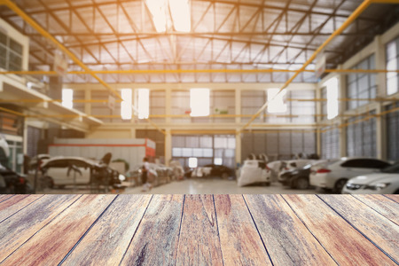 Wood table top with Car repair service centre interior blurred background. For create montage auto product display.の写真素材