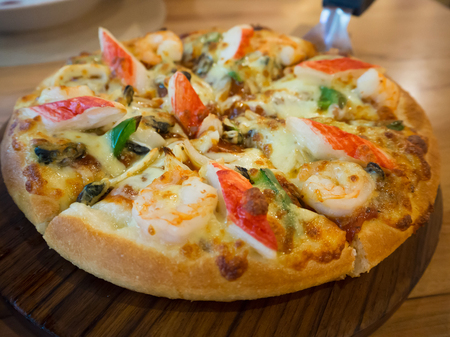 Delicious seafood pizza on wooden tableの写真素材