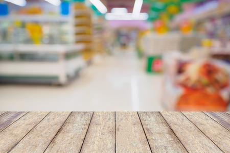 Supermarket abstract defocused blur background with wood tableの写真素材