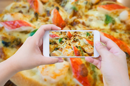 woman taking photo of Pizza and with mobile smartphoneの写真素材