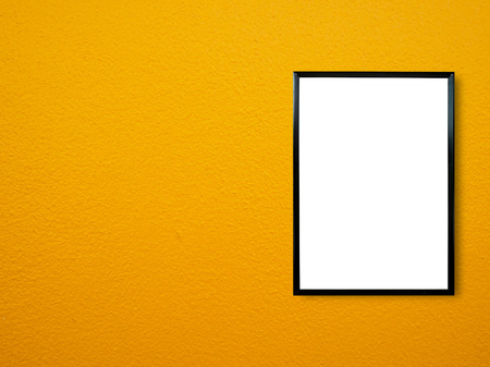poster frame on yellow paint wall backgroundの写真素材