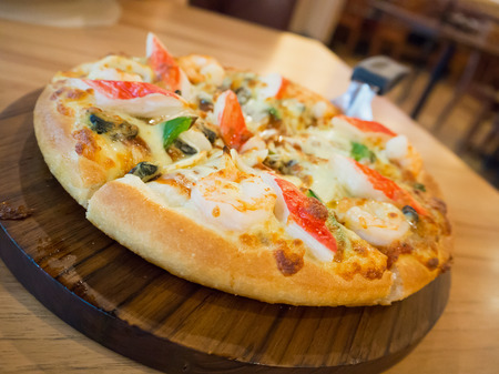Delicious seafood pizza on wooden tableの写真素材