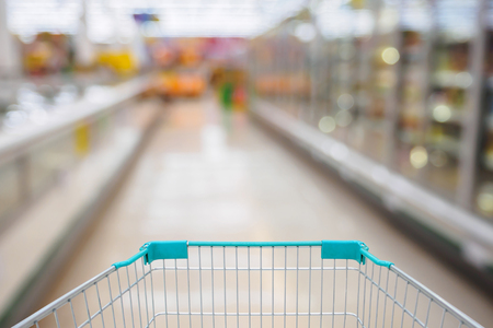 Shopping Cart View in Supermarket Aisle Milk Yogurt Frozen Food Freezer and Shelves with customer defocus backgroundの写真素材