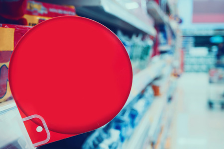 blank red discount sign display on supermarket shelvesの写真素材