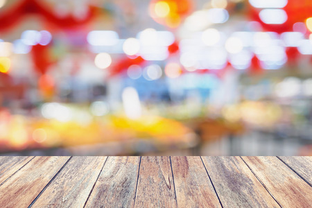wood table with abstract supermarket blurred backgroundの写真素材
