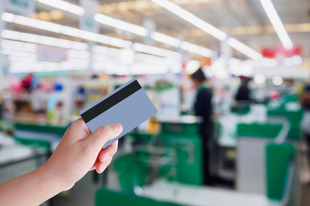 paying using credit card at supermarket checkout cashier counter in storeの写真素材