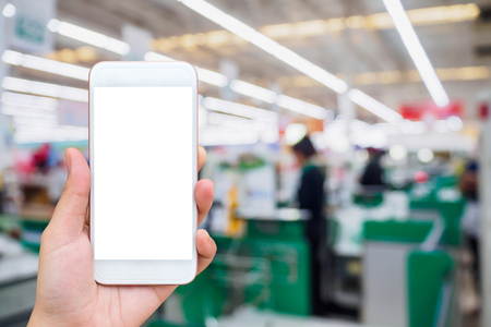 supermarket checkout cashier counter with hand hold mobile smartphoneの写真素材