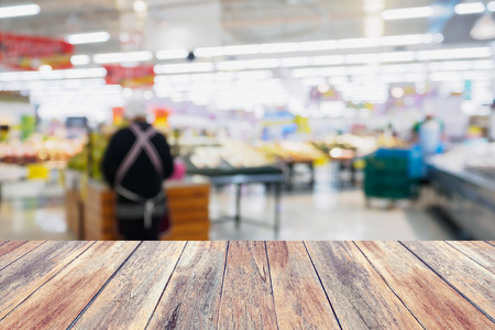 Supermarket abstract defocused blur background with wood tableの写真素材