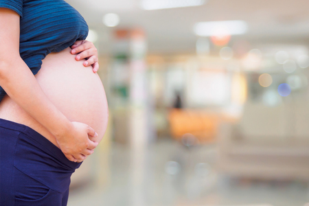 Pregnant woman with hospital blur backgroundの写真素材