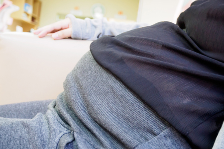 Pregnant woman sitting at sofa in the hospitalの写真素材