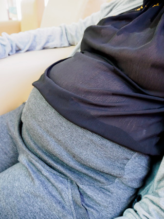Pregnant woman sitting at sofa in the hospitalの写真素材