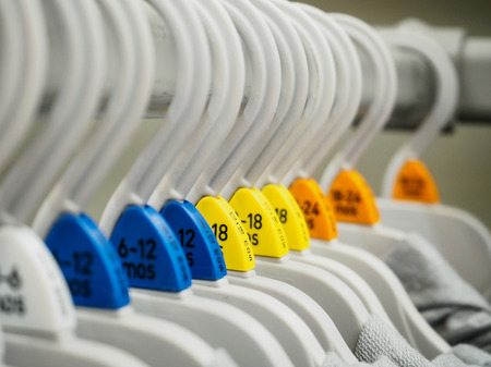 Baby clothes hang on shelf in clothing storeの写真素材