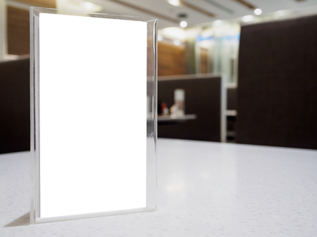 Mock up menu frame on table in the cafe restaurant, acrylic stand with white paperの写真素材
