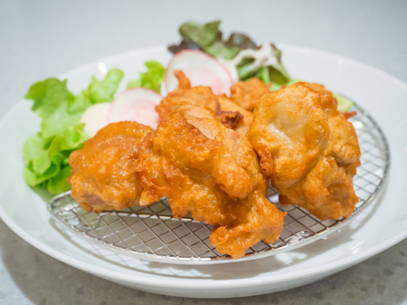 fried chicken Japanese style serve with vegatables and lemon on white plateの写真素材