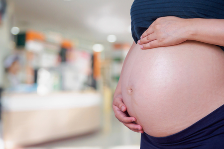 Pregnant woman with hospital blur backgroundの写真素材