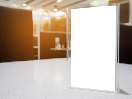Mock up menu frame on table in the cafe restaurant, acrylic stand with white paperの写真素材