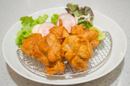 fried chicken Japanese style serve with vegatables and lemon on white plateの写真素材
