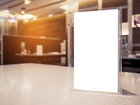 Mock up menu frame on table in the cafe restaurant, acrylic stand with white paperの写真素材
