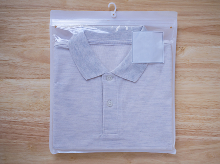 men t-shirts in plastic package on woodの写真素材