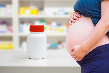 pregnant woman with medicine in the pharmacy store, drug use in pregnancy conceptの写真素材