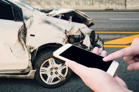 Driver using mobile smartphone with car crash accident on the roadの写真素材