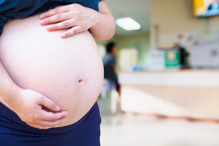 Pregnant woman with hospital blur backgroundの写真素材