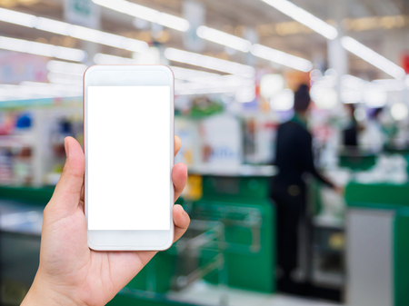 supermarket checkout cashier counter with hand hold mobile smartphoneの写真素材