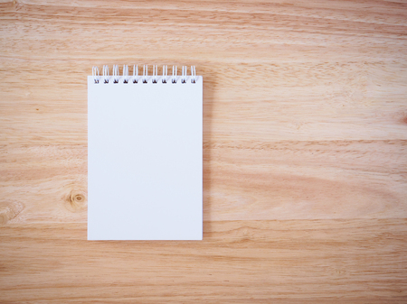 Notepad on the wooden desk tableの写真素材