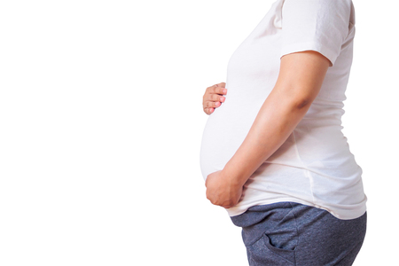 pregnant woman touching her belly isolated on white backgroundの写真素材