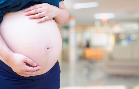 Pregnant woman with hospital blur backgroundの写真素材