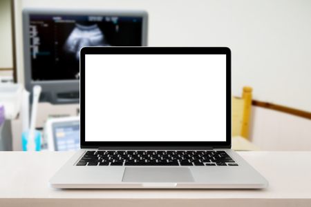 laptop computer on table with ultrasound diagnostic equipment backgroundの写真素材
