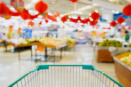 shopping cart with supermarket blur backgroundの写真素材