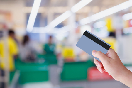 paying using credit card at supermarket checkout cashier counter in storeの写真素材