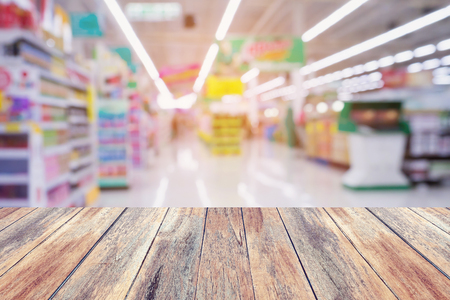 Supermarket store abstract blur background with wood tableの写真素材