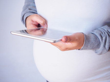 pregnant woman using tablet computerの写真素材