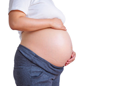 pregnant woman touching her belly isolated on white backgroundの写真素材
