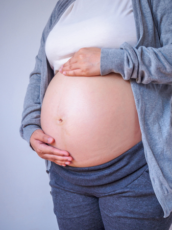 pregnant woman touching her belly close upの写真素材