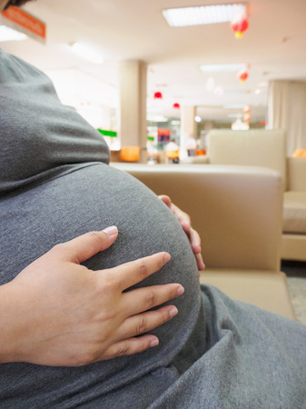 Asian pregnant woman touching her bellyの写真素材
