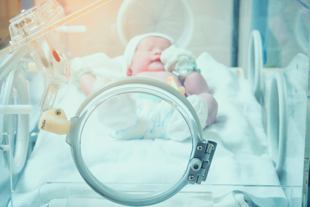 Newborn baby girl inside incubator in hospital post delivery roomの写真素材